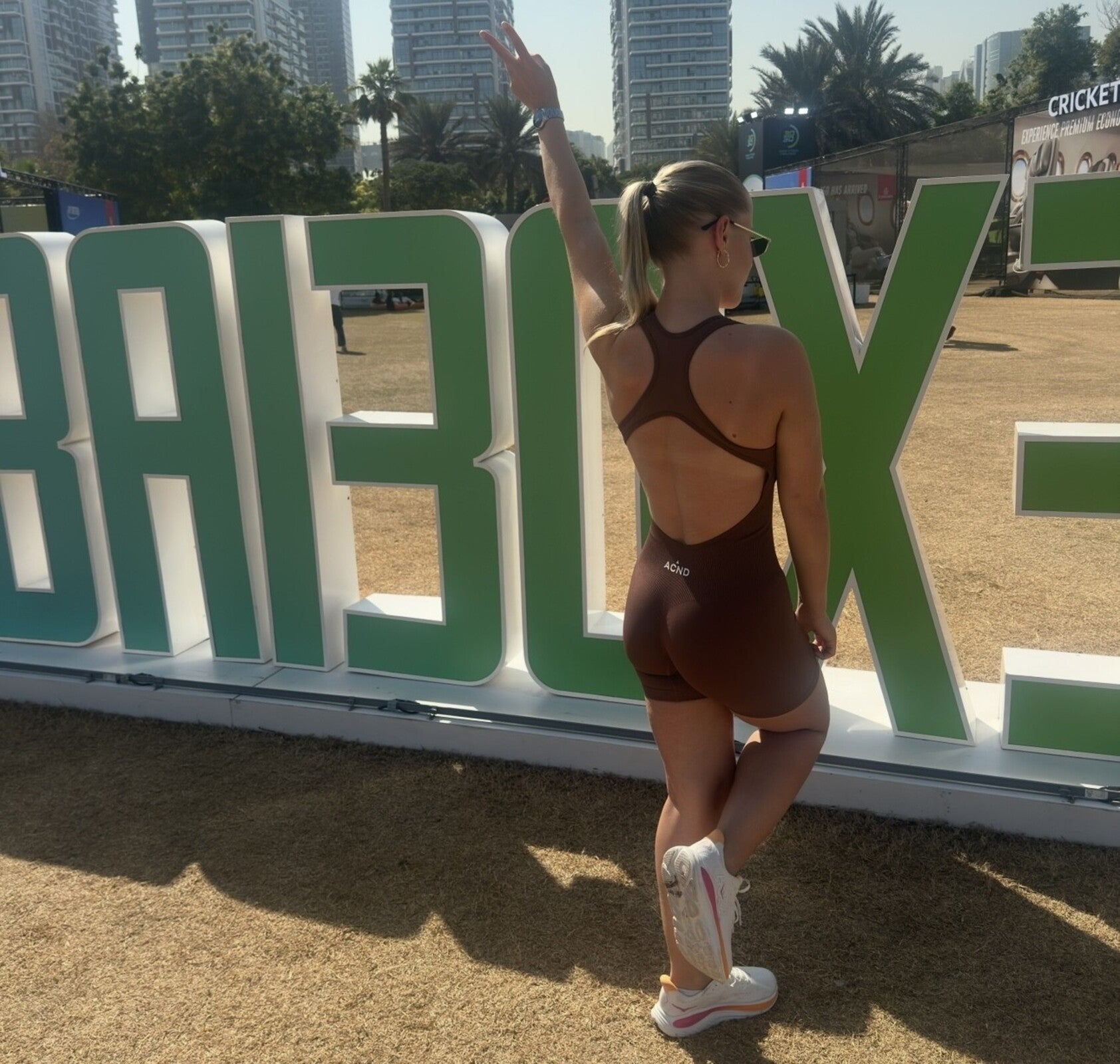 Ascend Active pink cross-back unitard on model, sculpting back and midsection